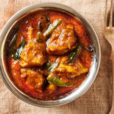 Close up of chilli chicken in an Indian style bowl from above.