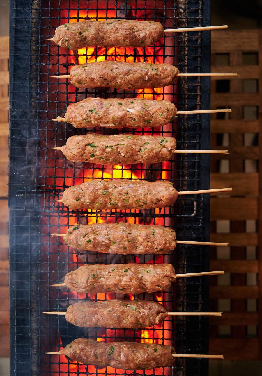 Uncooked seekh kebab as they hit the grill from above.