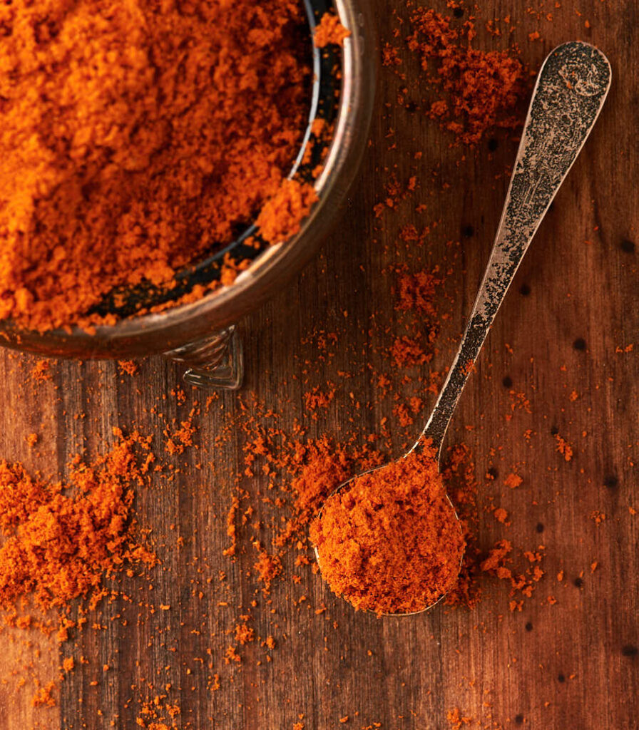 Malaysian curry powder in a small bowl with spoon from above.