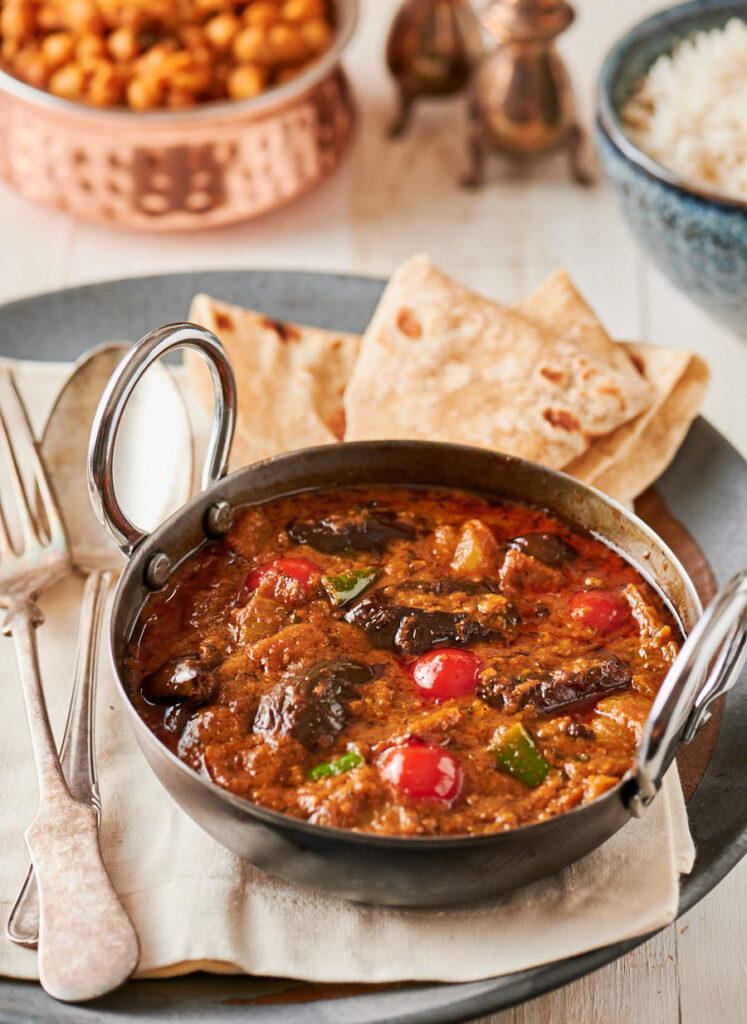 Eggplant curry in an Indian karai with chapati from the front.