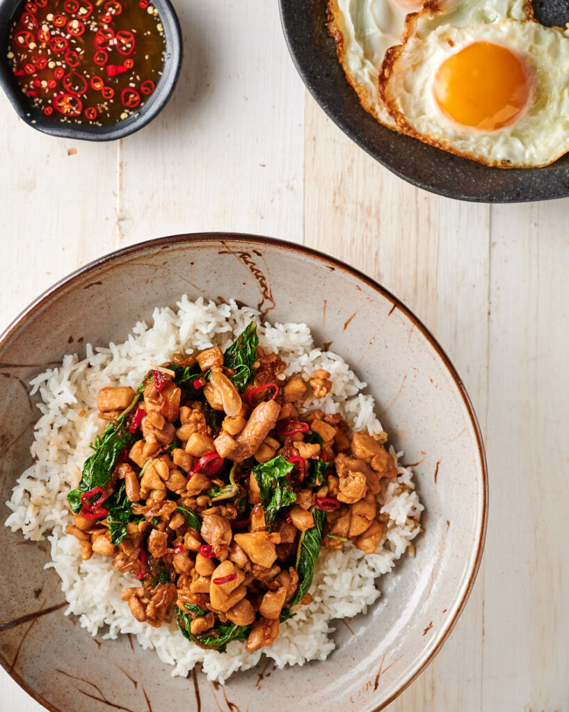 Bowl of Thai basil chicken with crispy fried egg.