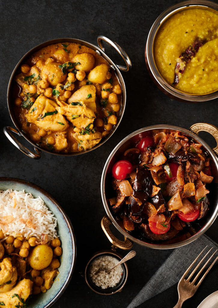 Chicken and chickpea curry and eggplant curry in serving bowls from above.