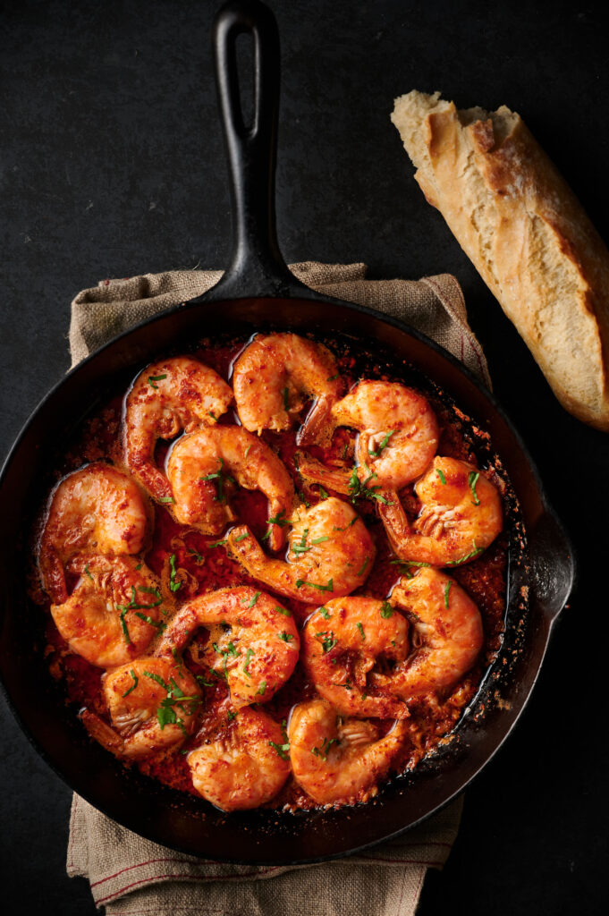 Korean bbq shrimp in a cast iron skillet with crusty french bread .