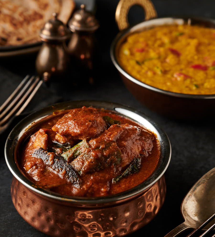 Ceylon chicken curry, dal , chapatis and cutlery table scene from the front.