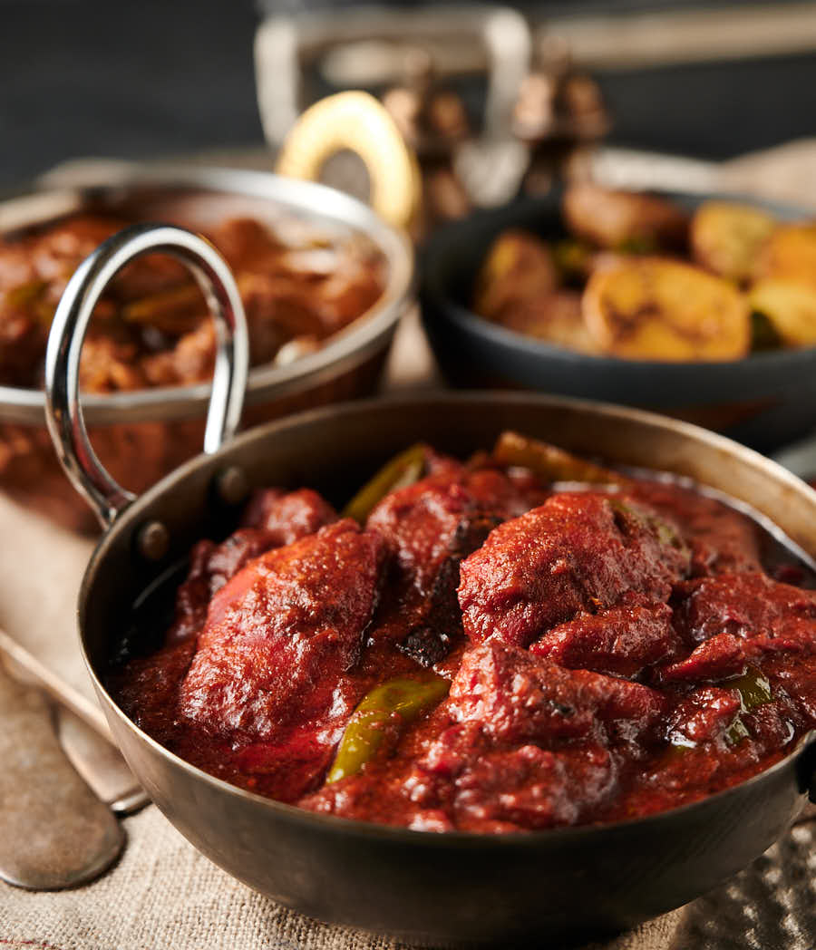 Naga chicken tikka curry in a carbon steel Indian styled bowl from the front.