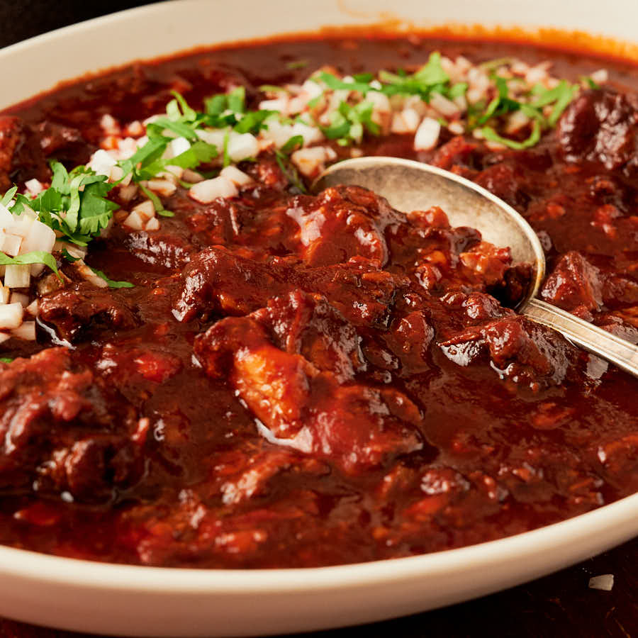 Closeup of spoon in a bowl of birria de res.