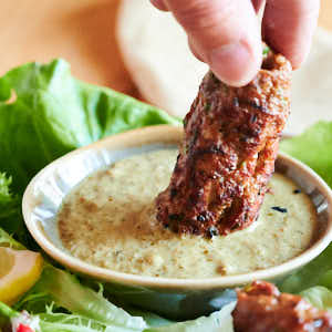 Closeup of seekh kebab in dip.