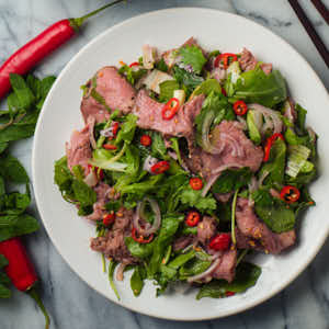 Thai beef salad on a white plate from above.