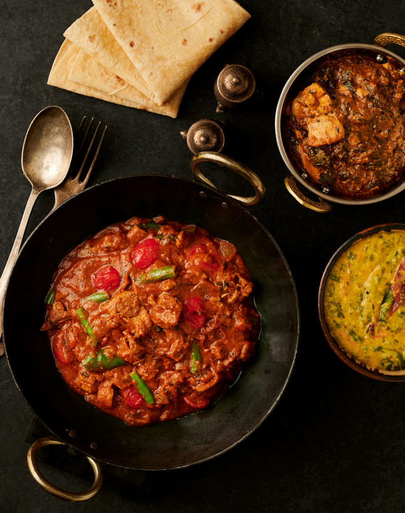 lamb bhuna, chicken curry, tarka dal and chapati table scene