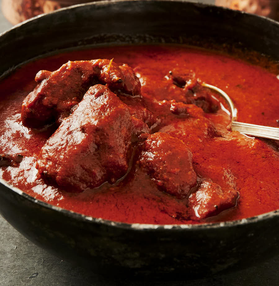 Spoon in a kadai full of chicken tikka masala