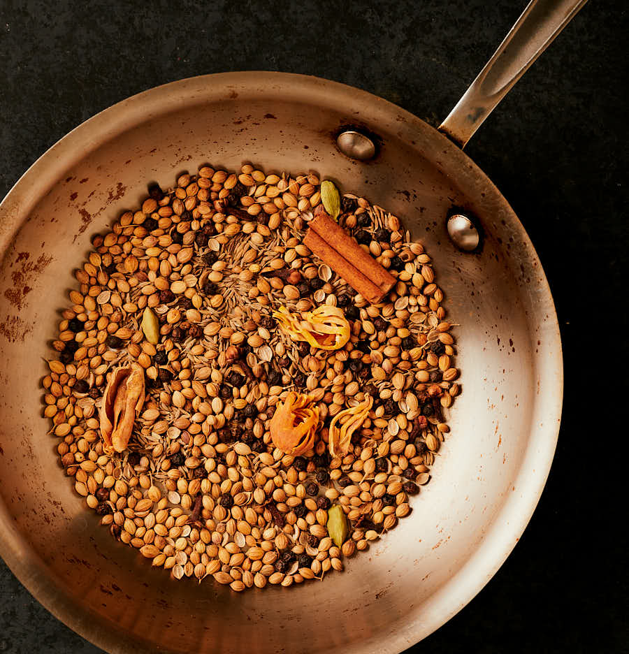 Whole spices toasting in a pan