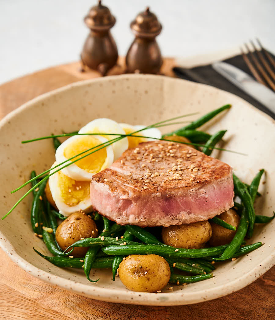 Bowl with Japanese seared tuna with beans, whole baby potatoes and sliced egg.