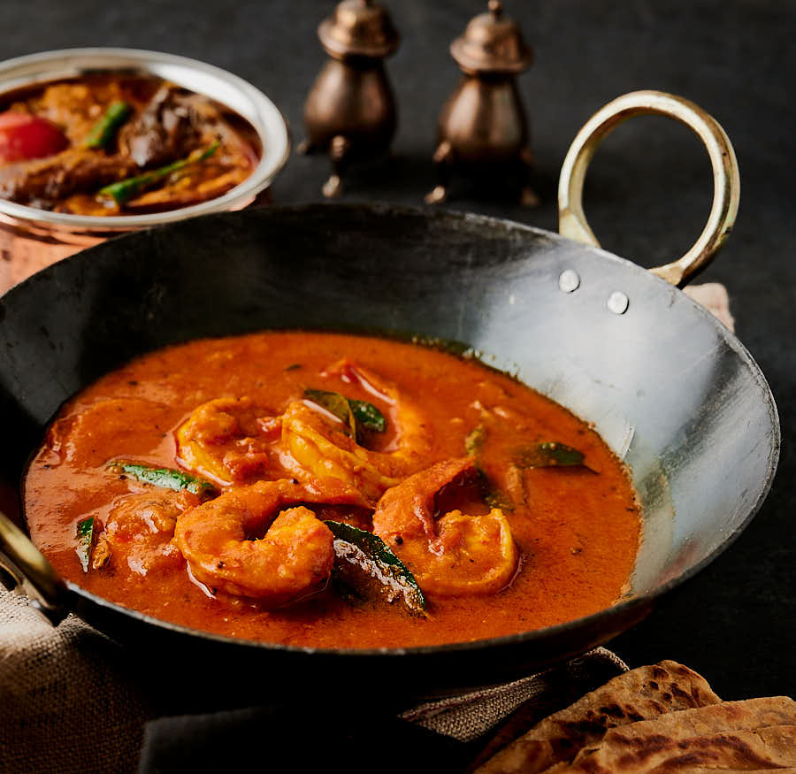 South Indian prawn curry table scene with eggplant curry.