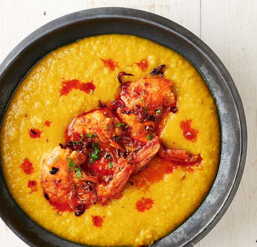 tandoori prawns floating in a bowl of dal and drizzled with spicy butter