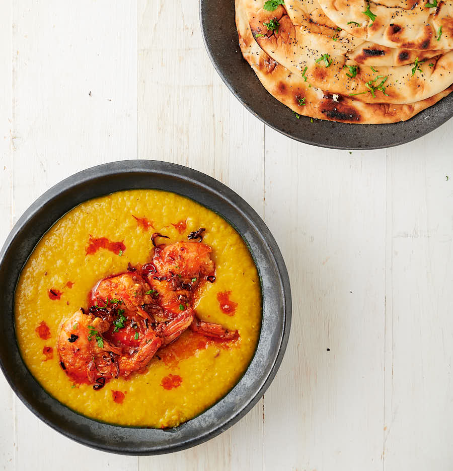 tandoori prawns on a bowl of dal with naan from above