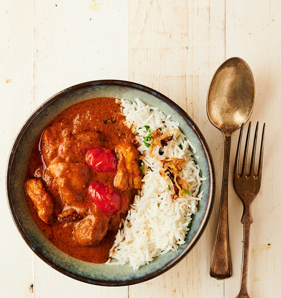 bowl of chicken rogan josh served with rice from above.