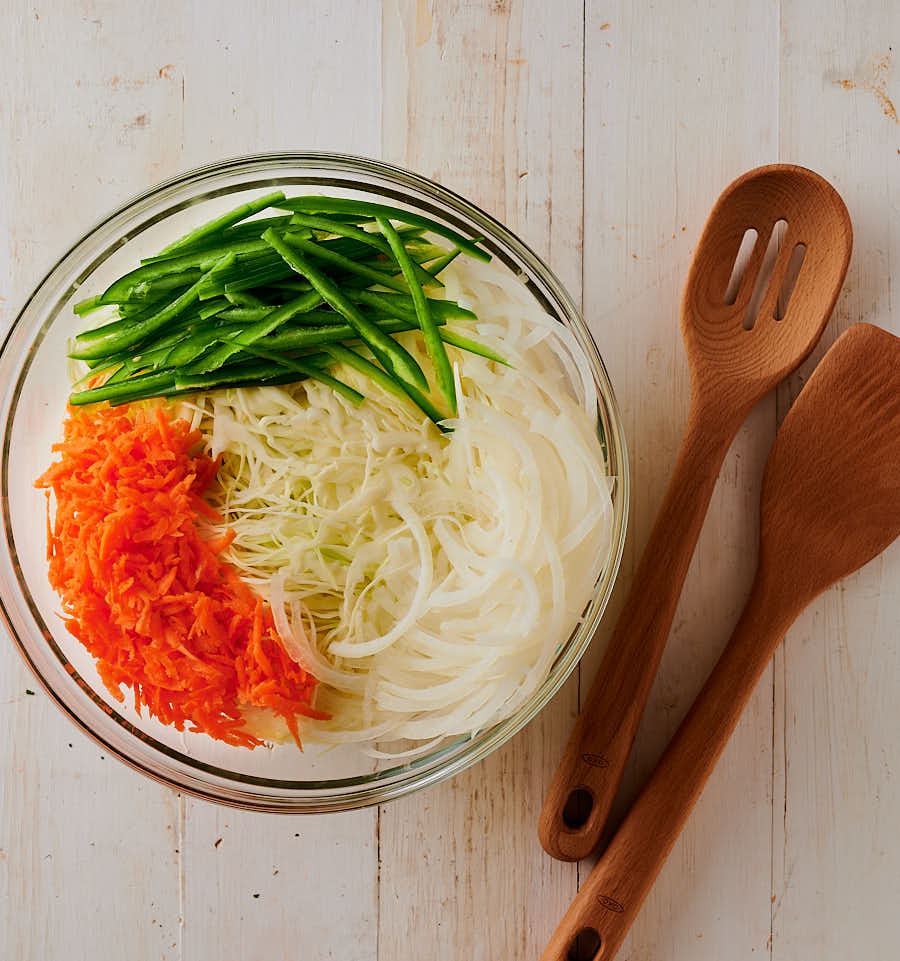 Indian slaw ingredients - jalapeno, carrrot, onion and cabbage in a bowl from above.