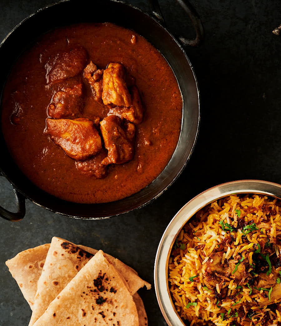 chicken pathia, biryani and chapati table scene from above.