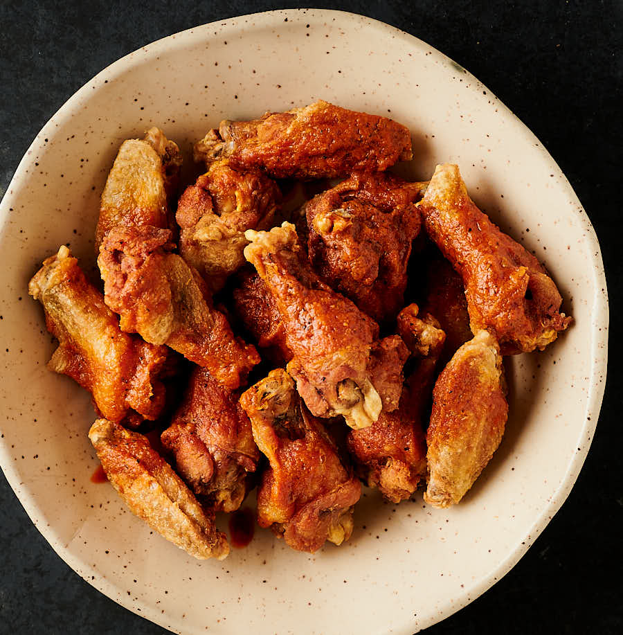 Chicken wings with vindaloo sauce drizzled overtop