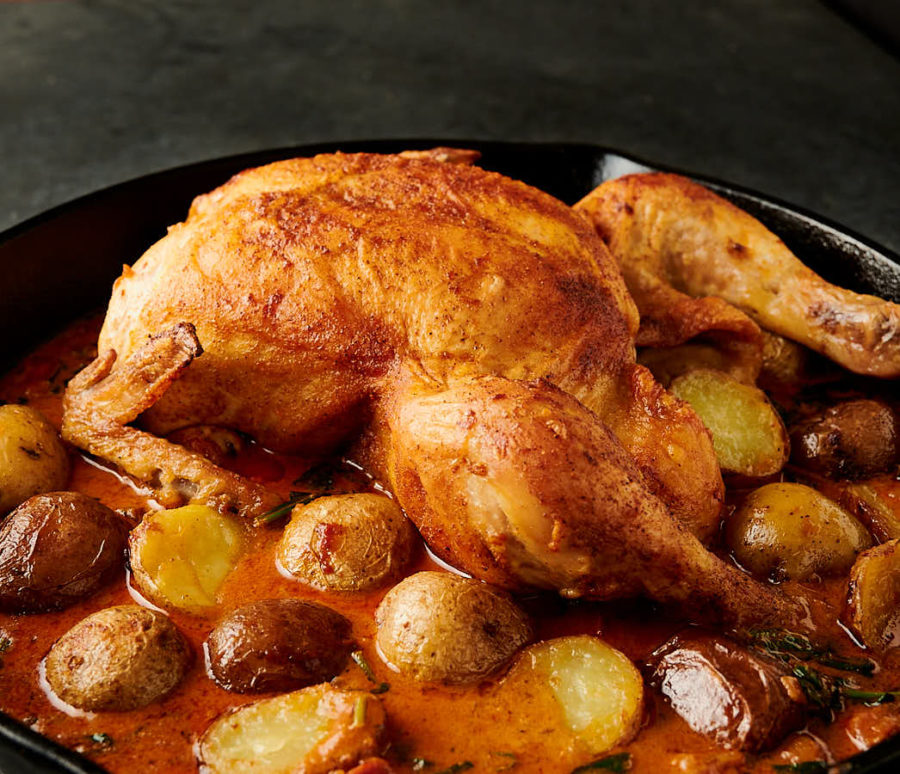 Bombay chicken and potatoes in a skillet from the front.