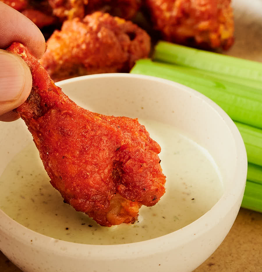 Vindaloo chicken wing and dipping sauce from the front.