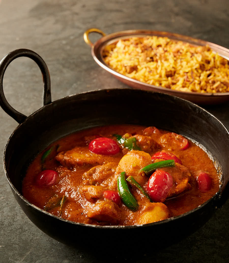 Bottle masala chicken curry in a black kadai