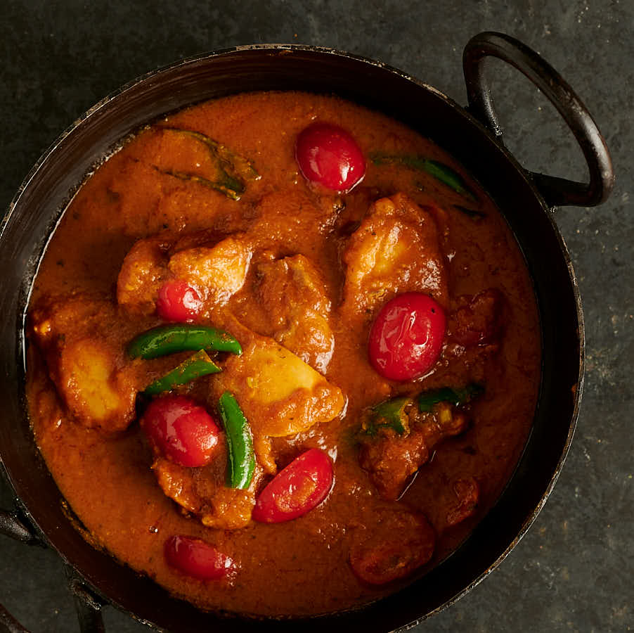 Bottle masala chicken curry in a kadai from above