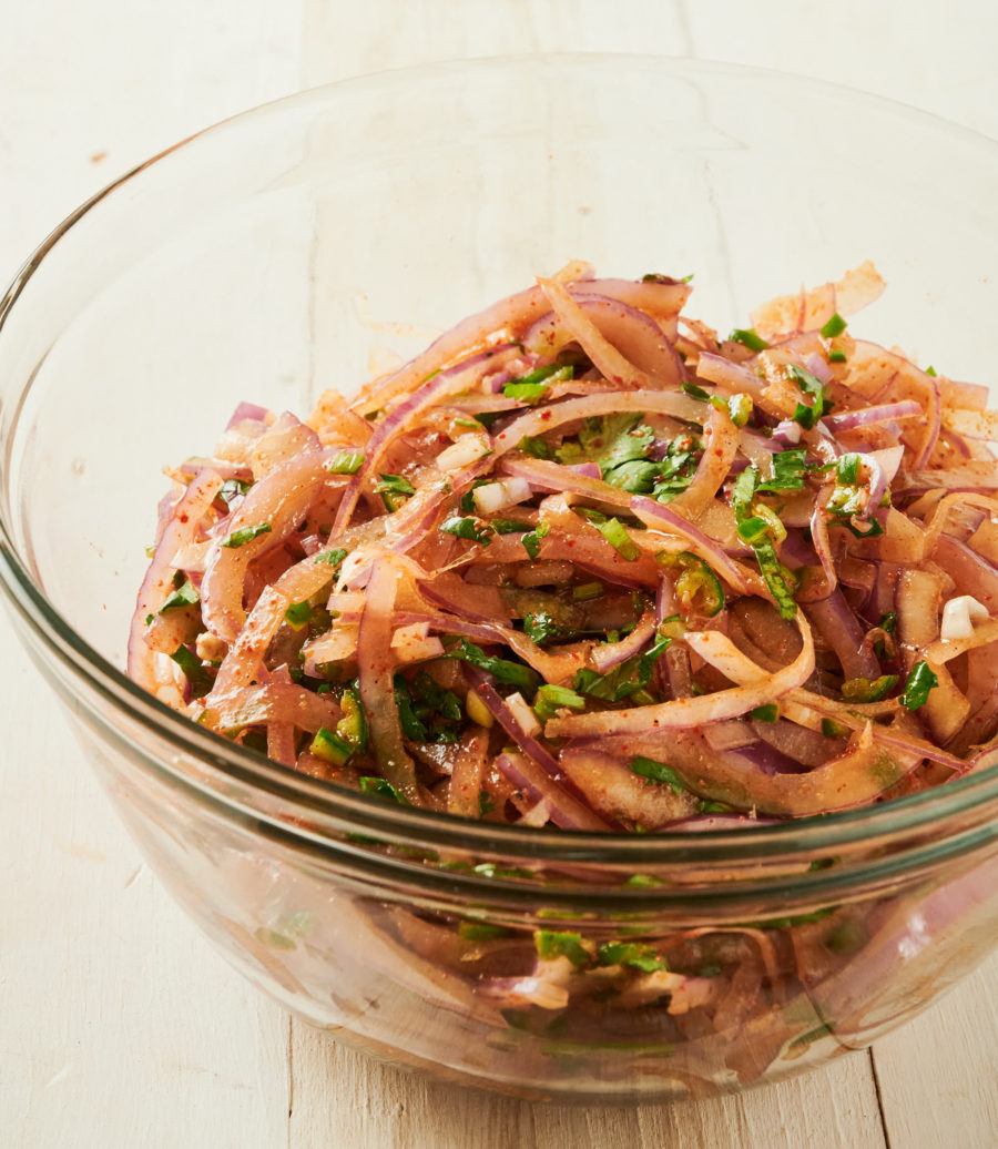 Clear bowl holding indian onion salad from the front