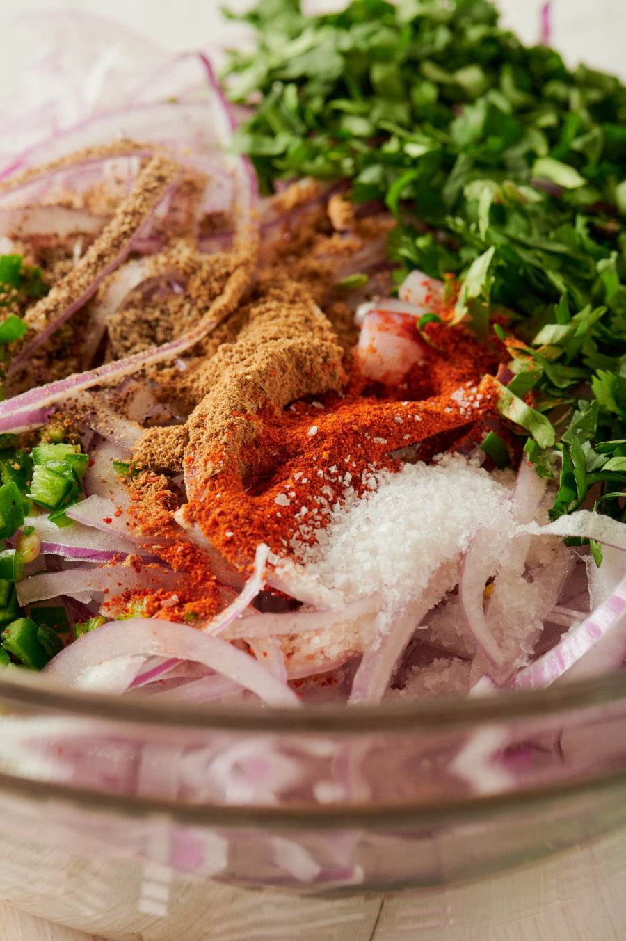 Indian onion salad ingredients in a clear bowl from above