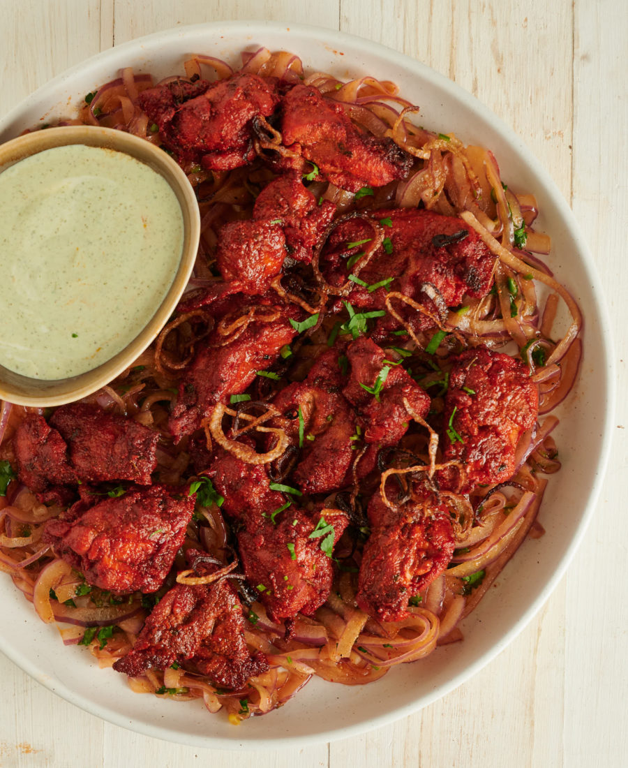 Tandoori chicken and dip on a bed of onion salad from above