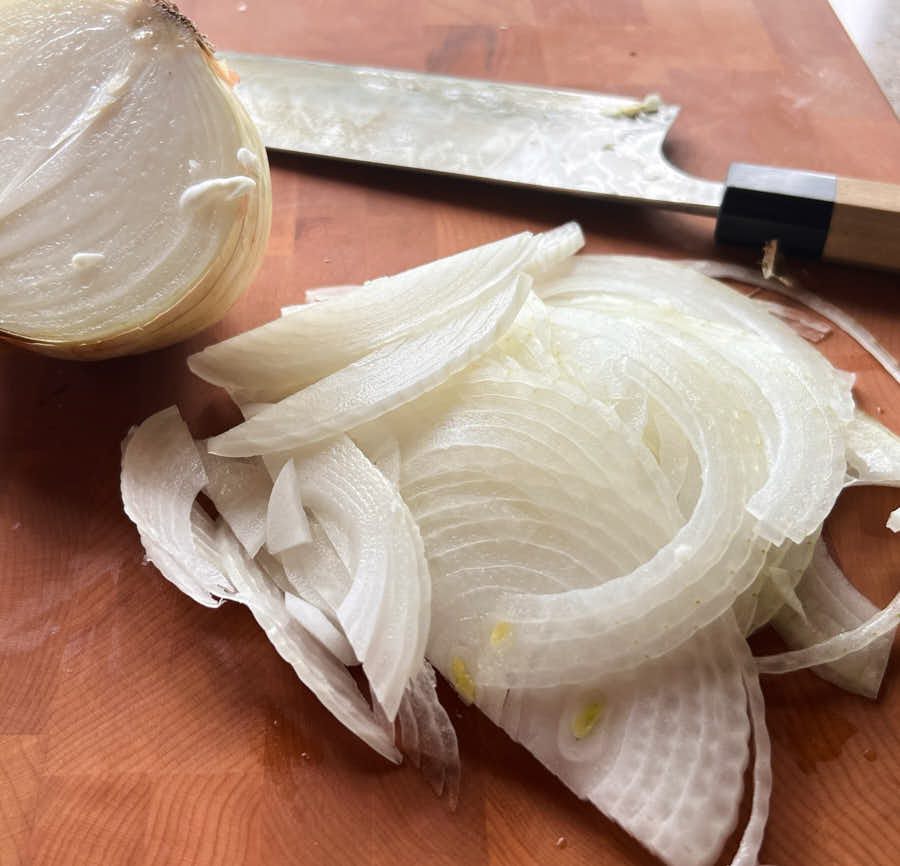 Thinly sliced onions on a cutting board