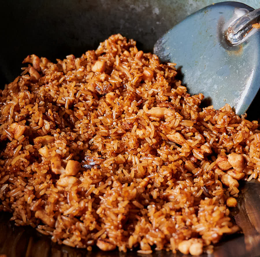 Chicken fried rice in a wok with a chuan