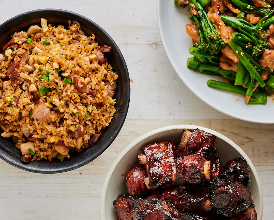 Table scene with fried rice, char siu ribs and sesame chicken and broccoli
