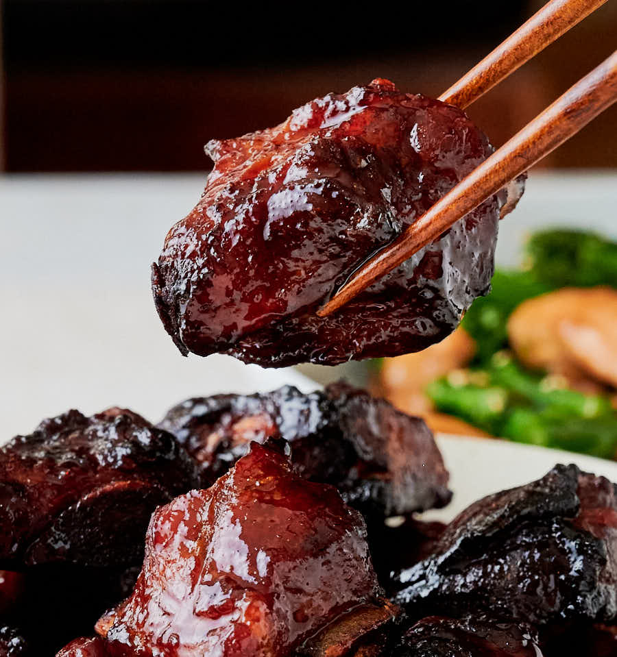 char siu rib held in chopsticks from the front