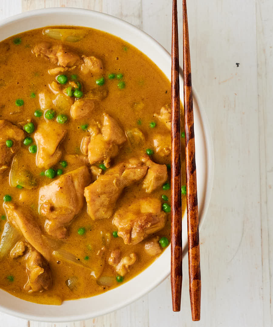 Chinese chicken curry in a bowl with chopsticks from above