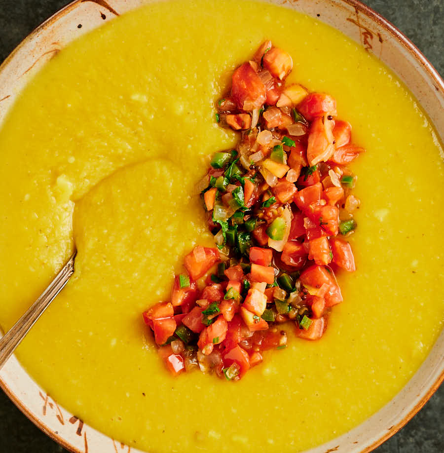 tomato masala on the surface of a bowl of dal from above