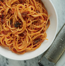 Bowl of spaghetti all'amatriciana and microplane grater