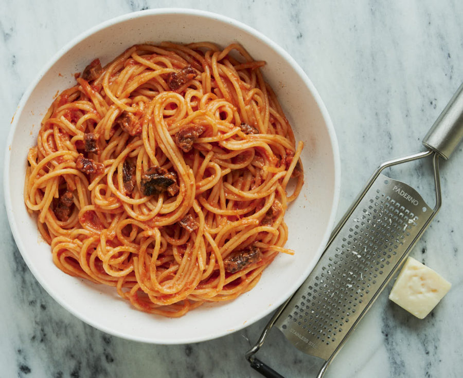 bowl of spaghetti all'amatriciana, pecorino romano and microplane cheese grater