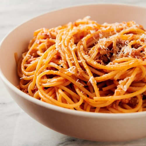 bowl of pork ragu with grated pecorino romano from the front