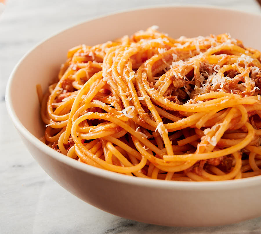 bowl of pork ragu with grated pecorino romano from the front