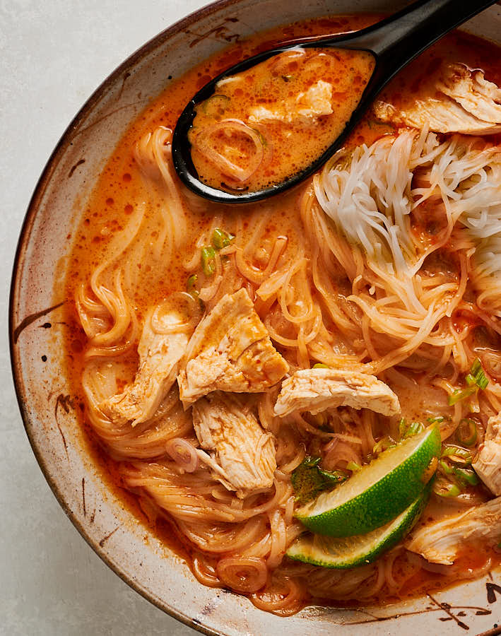 Bowl of tom kha gai noodle soup with spoon from above